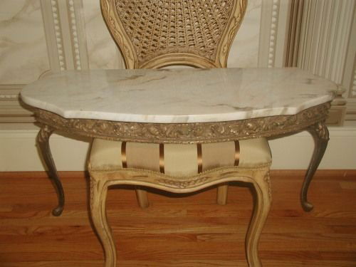 Italian Console Table Marble Top Gilt Early 1900's: Early 1900's Italian console table with attached marble top in antique cream background and camel and light brown veining with a hint of pink in some veins. Ornate gilt wood apron depicts acanthus lea