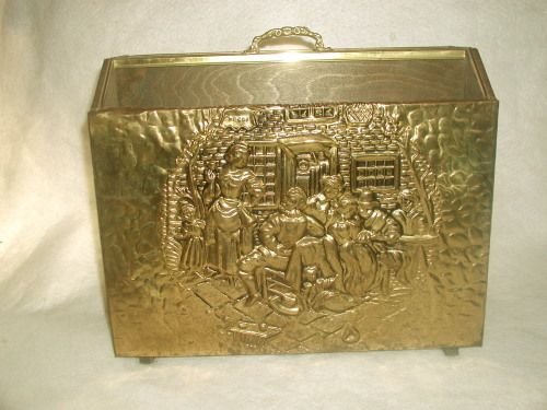 Brass magazine rack England 19th century: 19th century English brass over wood magazine rack. Hammered brass in repoussage style depicts several men,women and children conversing outside of the local Cabaret according to the signage on the de