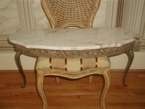Italian Console Table Marble Top Gilt Early 1900's: Early 1900's Italian console table with attached marble top in antique cream background and camel and light brown veining with a hint of pink in some veins. Ornate gilt wood apron depicts acanthus lea