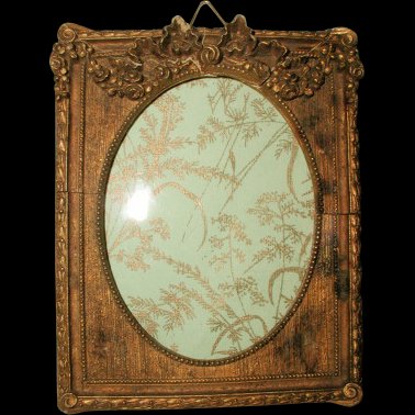 Gilt Wooden Frame With Glass 19th Century France: Beautiful late 19th century wood antique gilt frame with glass and raised carved floral swag above the oval opening with tiny bead trim. Additional ornate raised floral surrounds the outside of the fr
