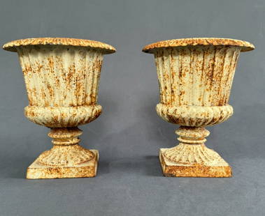 Cast Iron footed urns,Pair: Pair of cast iron fluted urns raised on square footed base circled with egg and dart decorative rim at collar. Large or small we pack, insure and ship it all. We make auctions easy!
