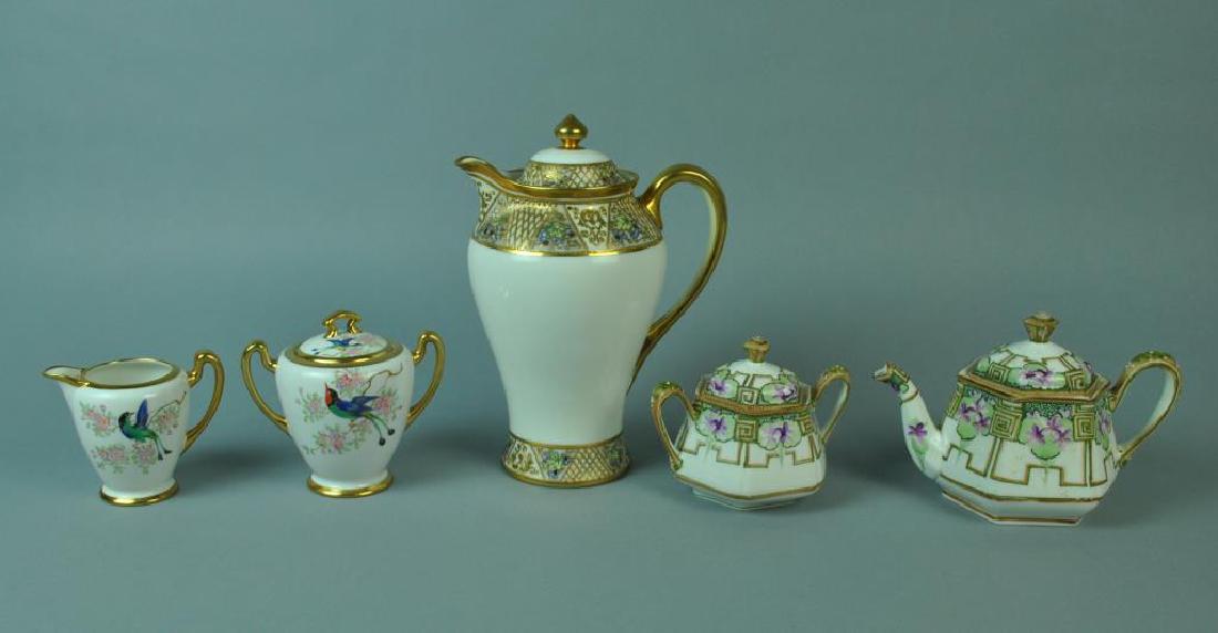 (5) NIPPON TABLEWARES: Including a chocolate pot, a bird and floral decorated creamer and sugar pair, and a moriage and violet decorated teapot with matching covered sugar, tallest 10in., no condition issues