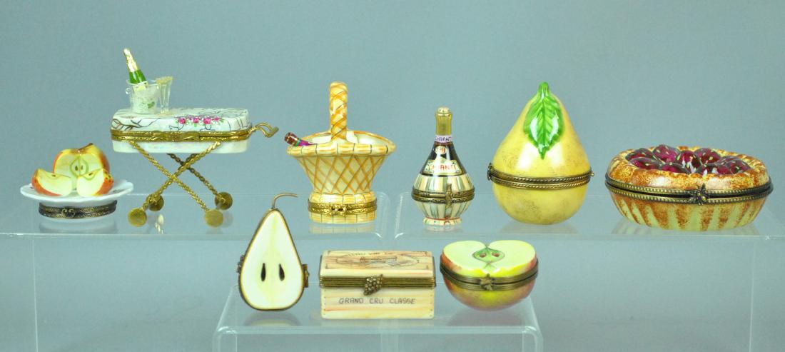(9) LIMOGES TRINKET BOXES - FRUIT & WINE THEMED: (9) LIMOGES TRINKET BOXES - FRUIT & WINE THEMED including a large strawberry pie, an upright pear, a sliced apple on plate, a halved apple, a halved pear, a Grand Cru wine box opening to reveal 2 bott