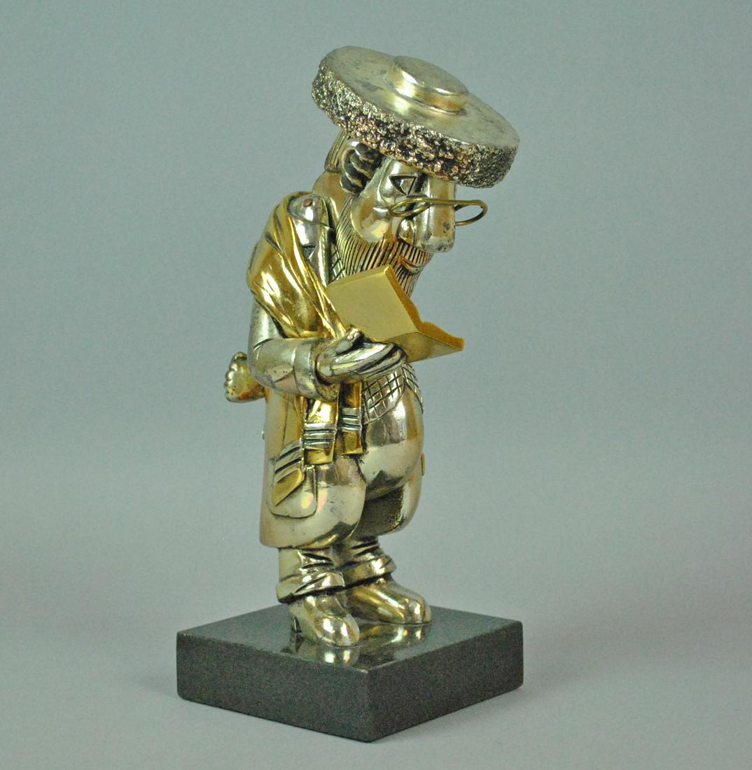 FRANK MEISLER JUDAICA READING REBBE SCULPTURE: FRANK MEISLER JUDAICA READING REBBE SCULPTURE in mixed metal, hinged head, signed and numbered on the back of the arm, 'Frank Meisler Israel 149/560', minor oxidation, on marble base, overall 11.5in.