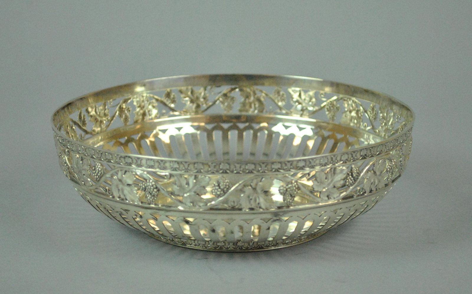 GERMAN 800 SILVER WINE COASTER BY H. MAU: GERMAN 800 SILVER WINE COASTER BY H. MAU the pierced rim decorated in grape leaf and grape cluster motif, stamped with H. Mau, and with crescent and crown punch, 2x7in., 9.7ozt.