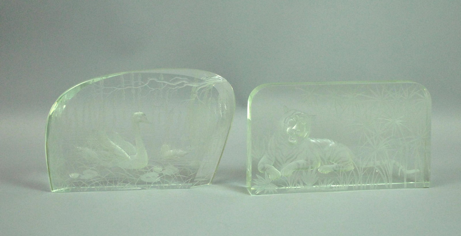 (2) MOSER INTAGLIO CUT & ETCHED TABLE PLAQUES: (2) MOSER INTAGLIO CUT & ETCHED TABLE PLAQUES one depicting a reclining tiger, the other a swan and cygnet, both amongst textured grasses, etched oval Moser marks, no condition issues, tallest 5.75in.