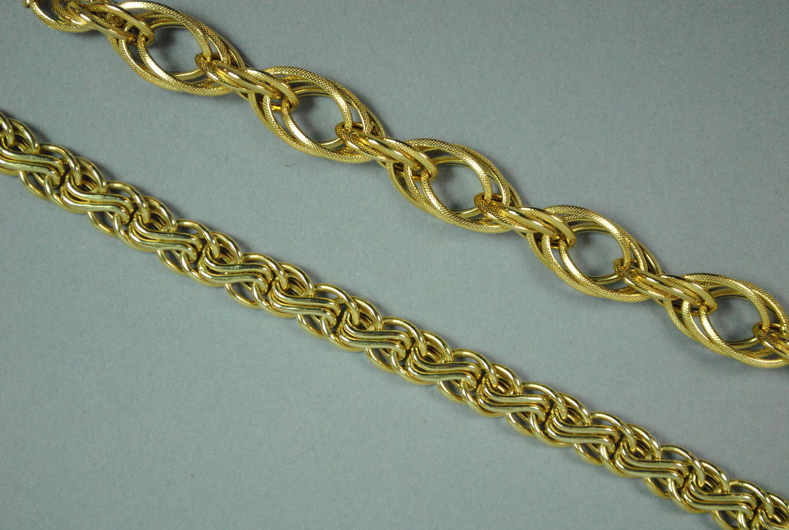 (2) 14K FANCY LINK BRACELETS: including a triple oval link stamped 585, height 10mm, and a swirl link stamped 14K Italy, height 7mm, each 7in., no condition issues, gross weight 12.9gms.