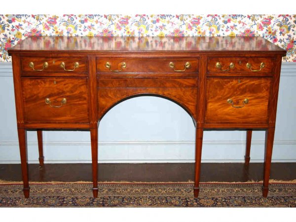 FEDERAL MAHOGANY INLAID SIDEBOARD: probably New York, c.1810, with figured crotch front including a hidden drawer, ornately inlaid with ebony stringing and banding, shield swags and tassels, tapered legs on spade feet, 38x65x24in.