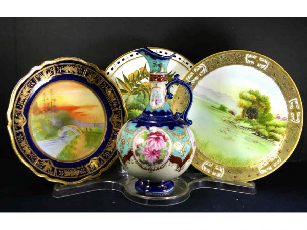 THREE SCENIC PLATES AND A EWER: including a Nippon plate depicting a bridge over brook with cobalt and gilded border, a Nippon plate depicting a lakescape with enamel beaded border, an unmarked plate depicting a swan under a palm le