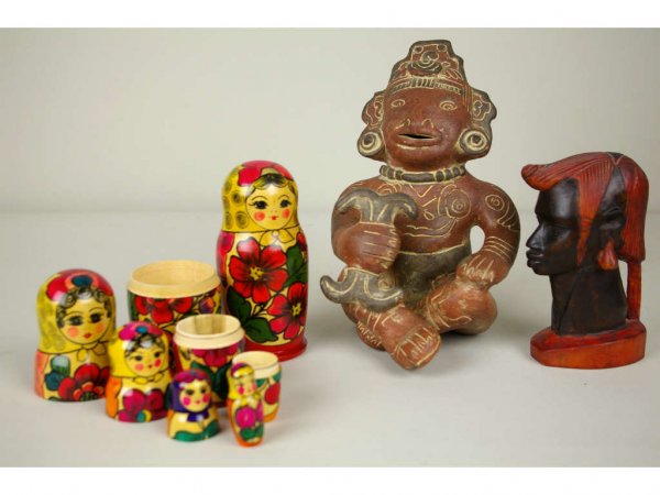 4-PIECE TOURIST'S LOT: includes two Russian nesting dolls, a wood carved head marked Kenya, and a pottery sculpture of a seated figure