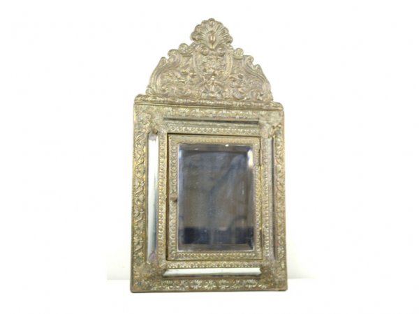 ANTIQUE WOOD AND BRASS MIRRORED WALL CABINET: with beveled glass door opening to a compartmental interior, floral and foliate brass panels, mirrored side panels, 24x14x3in. The Knoop Collection