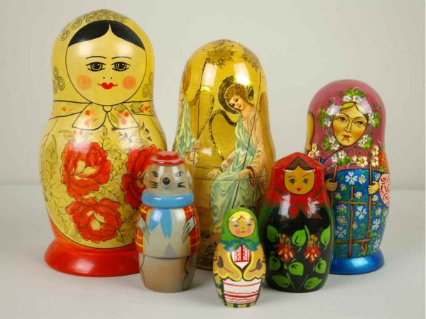 SIX LACQUERED NESTING DOLLS: includes two artist signed examples by H. Kapeba, 1993-94, a traditional Russian set, a Polish set, etc., tallest 10in.