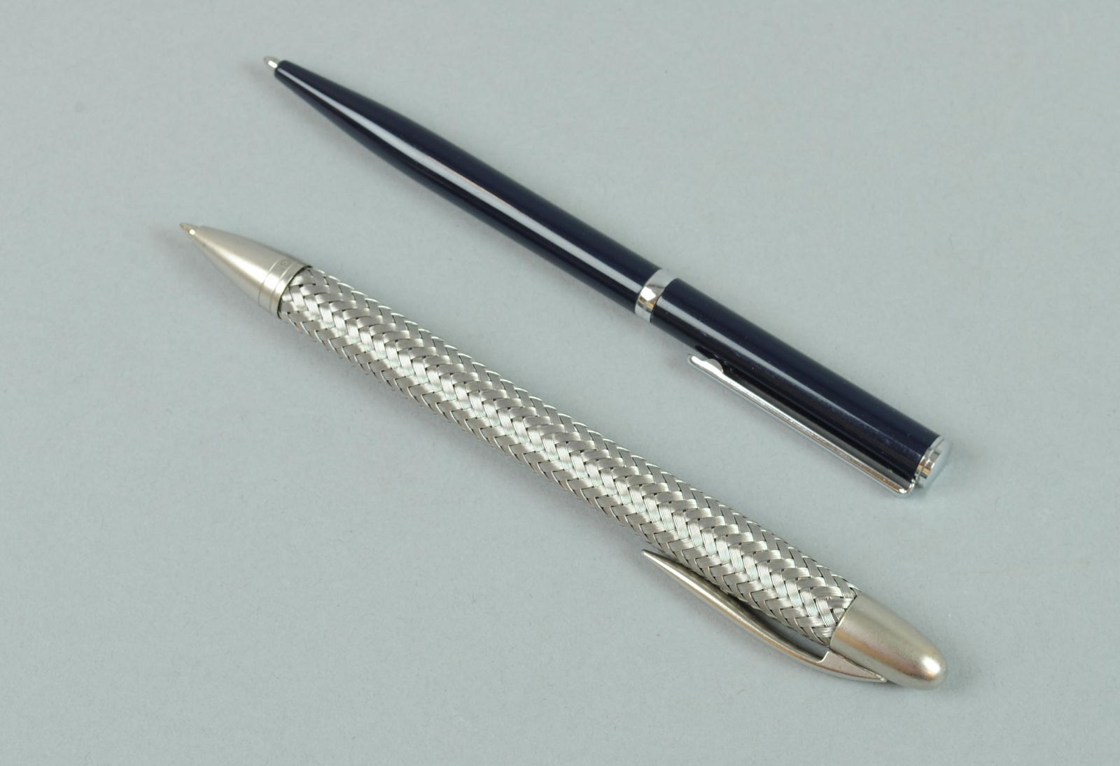 (2) COLLECTOR'S PENS - CHOPARD AND PORSCHE: including a Porsche Design TecFlex (stainless steel weave) ballpoint pen, operation is through depression on the top of the pen which flexes the whole barrel, (needs a new refill), and a twist open Ch