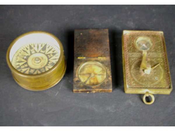 THREE ANTIQUE COMPASSES: including a transportable brass with screw-on cover and dial marked Boston, a brass compass/sundial combination with Persian lettering, and a hinged wooden case pocket variety, longest 4in. The Knoop