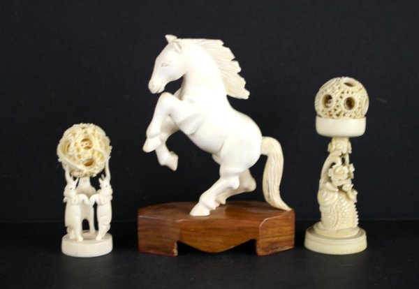 THREE CARVED IVORY OBJECTS: including a horse on attached wood stand, and two mystery balls on stands, tallest 5in. NO INTERNATIONAL SHIPPING.