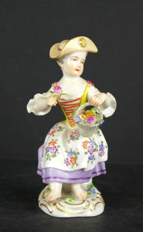 MEISSEN FIGURE OF A SEATED GIRL WITH FLOWER BASKET: marked Germany / 14 / 1490, blue crossed swords mark, 5in.