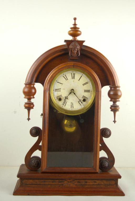 ANSONIA VICTORIAN WALNUT MANTLE CLOCK: figural dome top with carved face, 23x14in.