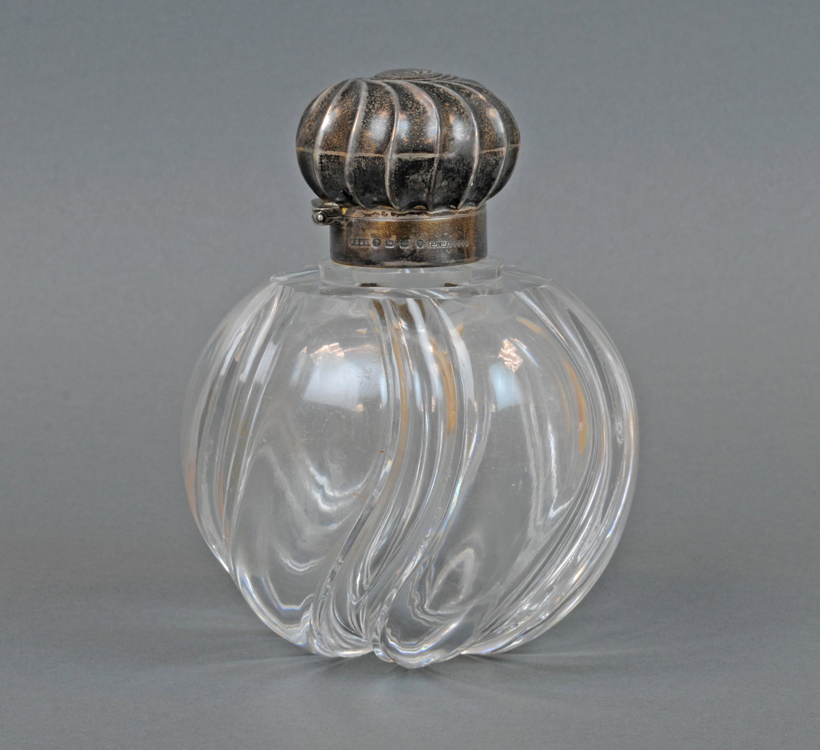 LG. TIFFANY & CO. STERLING & CRYSTAL SCENT BOTTLE: the sterling hinged cap bearing British punch marks for Birmingham, sterling, Victoria, 1889, and maker John Grinsell & Sons, retailer 'Tiffany & Co. New York' inscribed on inside lip, numerous minor 