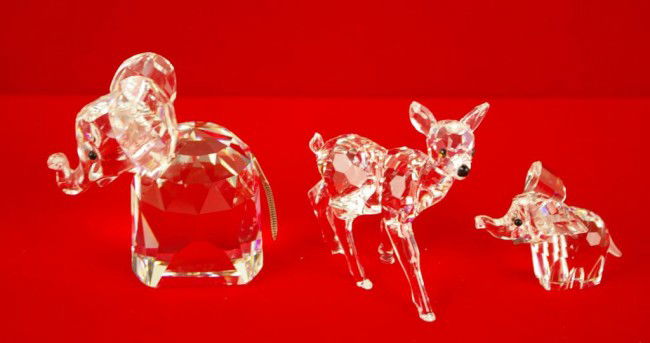 THREE SWAROVSKI CRYSTAL ANIMAL FIGURES including a: THREE SWAROVSKI CRYSTAL ANIMAL FIGURES including a 2.5" elephant, a 1" elephant, and a 2.5" deer (deer with original box)