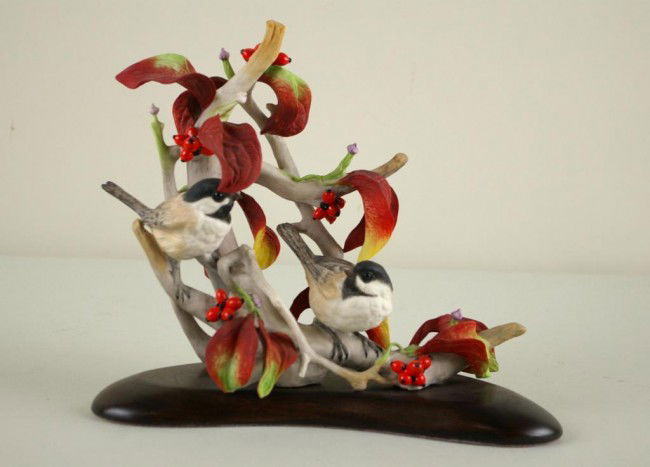 CYBIS BIRD FIGURAL GROUP depicting chickadees nest: CYBIS BIRD FIGURAL GROUP depicting chickadees nestled in a branch with berries and autumn leaves, on attached wood base, 9x10in.