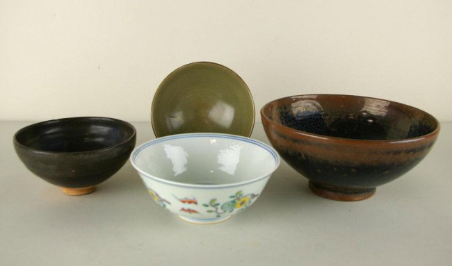 FOUR CHINESE CERAMIC BOWLS: FOUR CHINESE CERAMIC BOWLS including two brown-glazed bowls, a green-glazed bowl, and one decorated with bats amongst fruit trees, largest diameter 9in.