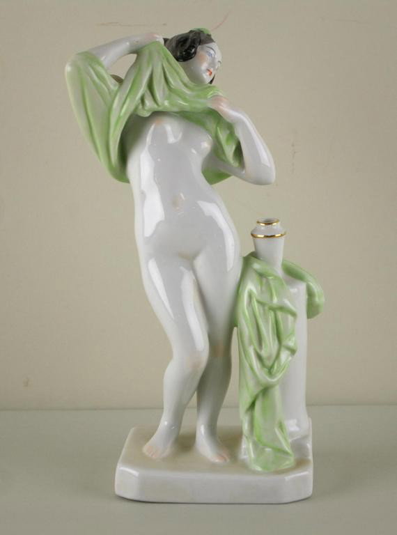 ZSOLNAY FIGURE OF A DRAPED NUDE: ZSOLNAY FIGURE OF A DRAPED NUDE standing next to a bud vase, 10in.