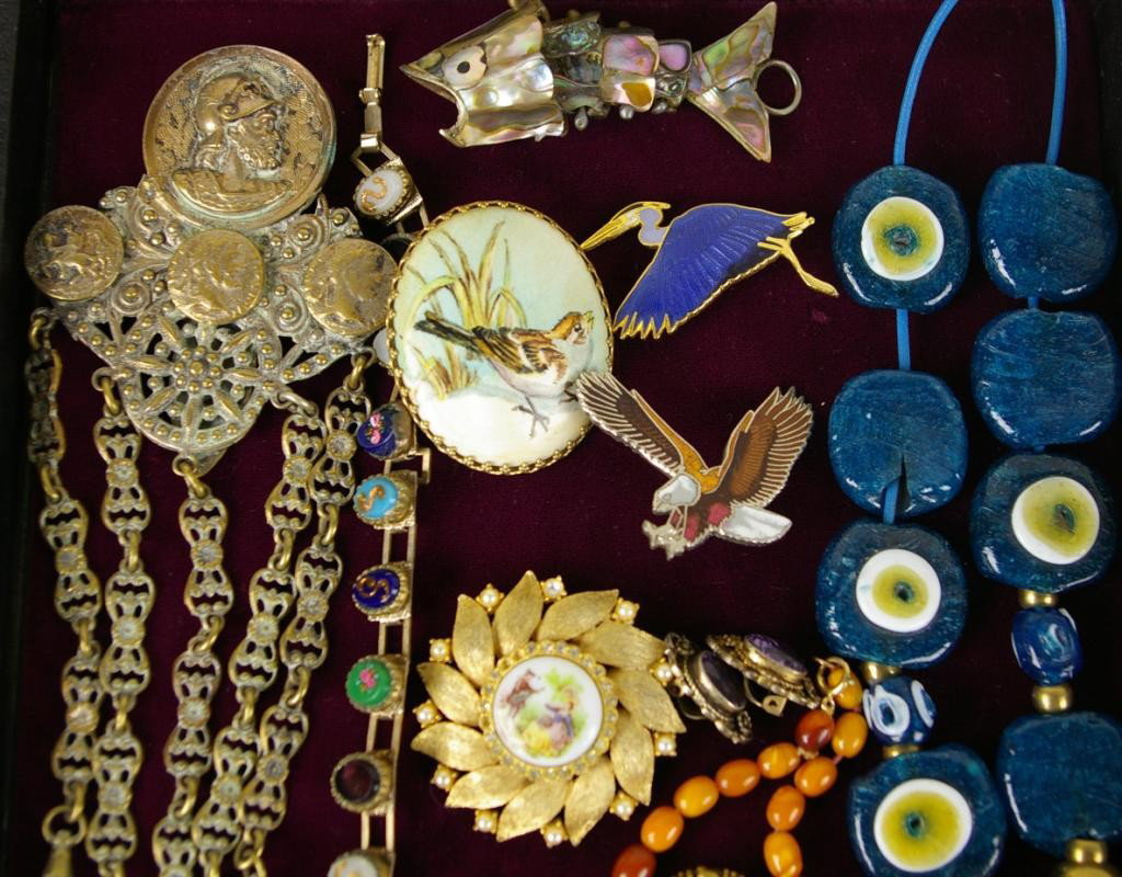 10+ PIECE COSTUME JEWELRY GROUP: including brass chatelaine (missing one clip), Southwestern bolo, enameled stork and eagle pins, Czechoslovakia belt buckle, mother of pearl fish pendant, etc.