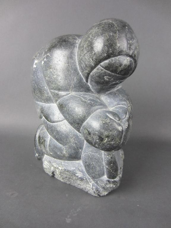 INUIT CARVED SOAPSTONE FIGURAL GROUP: possibly an Eskimo removing Walrus tusks, Canadian Eskimo Art label, numbered 918, 11x8in.