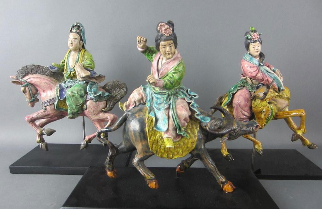 THREE ASIAN EARTHENWARE FIGURAL ROOF TILES: each depicting a rider, on horseback, water buffalo and stag, mounted on wood stands, all in as is condition, tallest 12in.