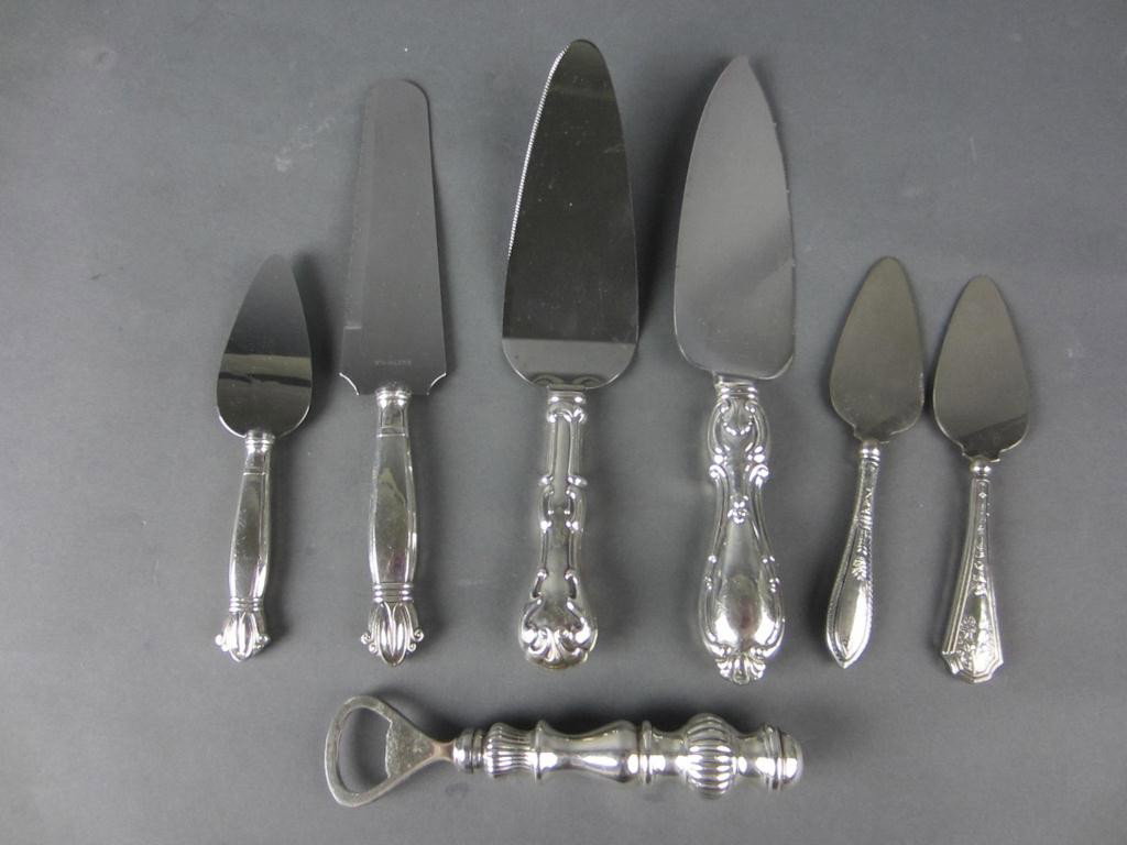 7 STERLING-HANDLED SERVING UTENSILS: including cake/pie servers, cheese servers, a bottle opener, etc.