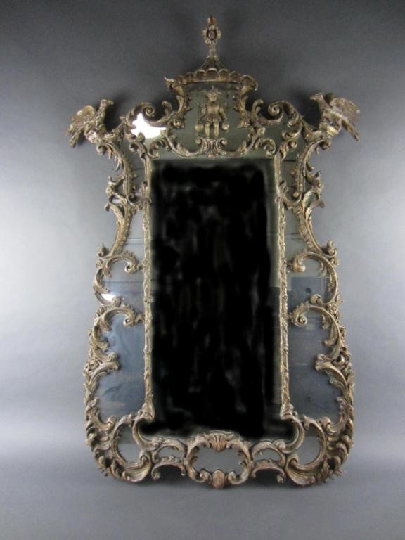 ANTIQUE CARVED GESSO AND GILTWOOD MIRROR: likely English Chinese Chippendale, the pagoda-roof crest above an Asian water carrier figure flanked by perched phoenix, allover scrollwork decoration, wear and losses, 55x36in.