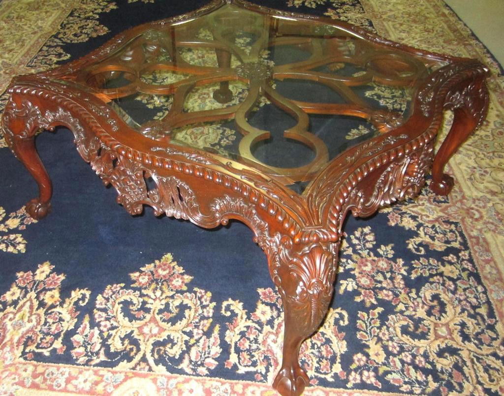 MAITLAND SMITH MAHOGANY GLASS-TOP COCKTAIL TABLE: of serpentine square form with cabriole knees, on ball and claw feet, Indonesia label and bar code label of Maitland Smith, 20x40in.