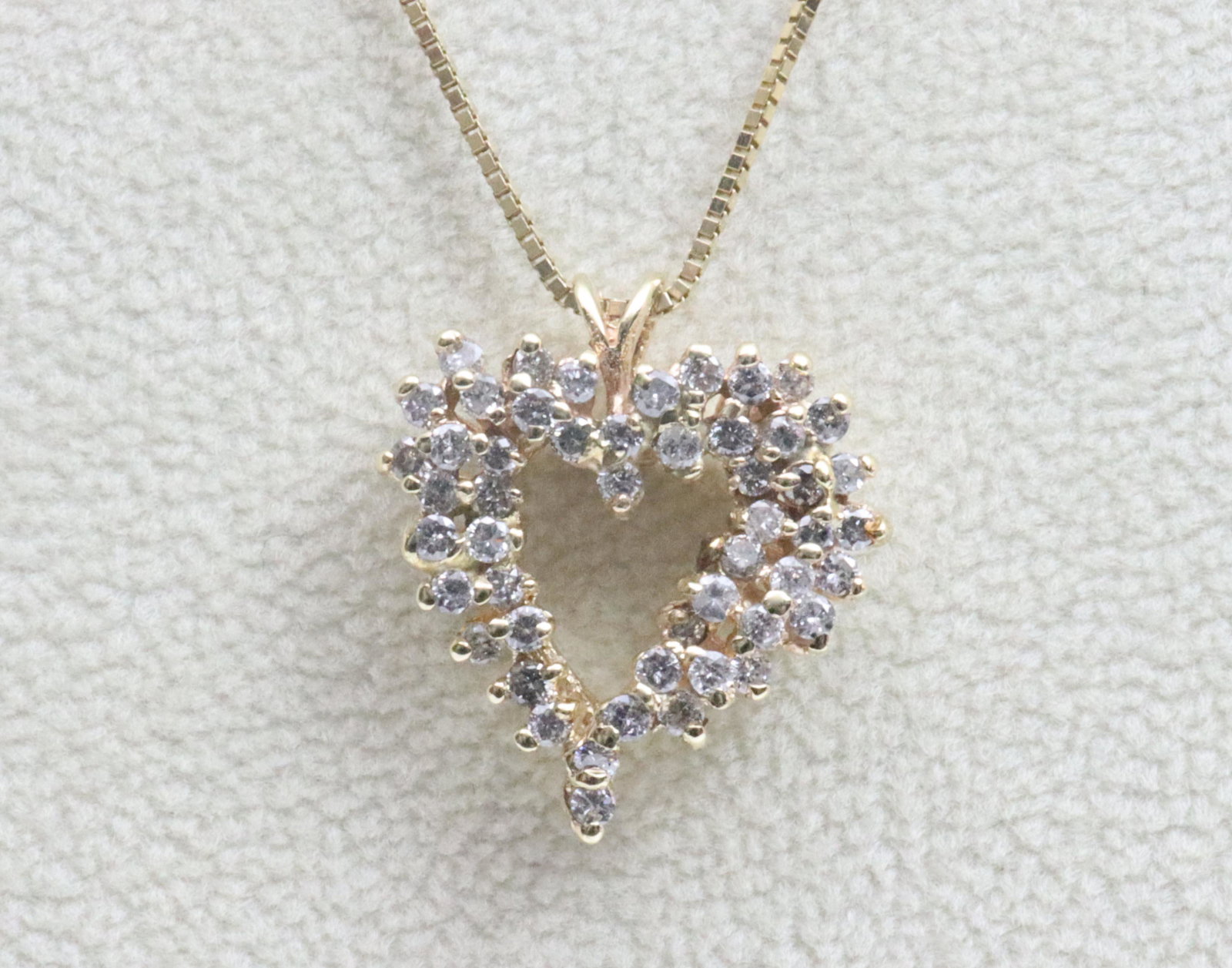 14K DIAMOND HEART PENDANT ON CHAIN: the pendant set with 50 round diamonds approx. 1.00 carat, 20x18mm, on 18” Italian box link chain, each in yellow gold, gross weight 5.7gms.