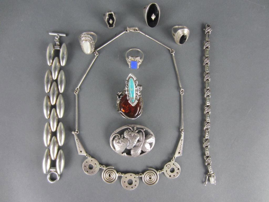 11-PIECE SILVER AND SILVERTONE JEWELRY GROUP: marked sterling pieces include an Art Moderne necklace, amber-style and strawberry brooches, a large onyx ring with accent diamond, five more rings (some stones with minor abrasions), and a marcasite 
