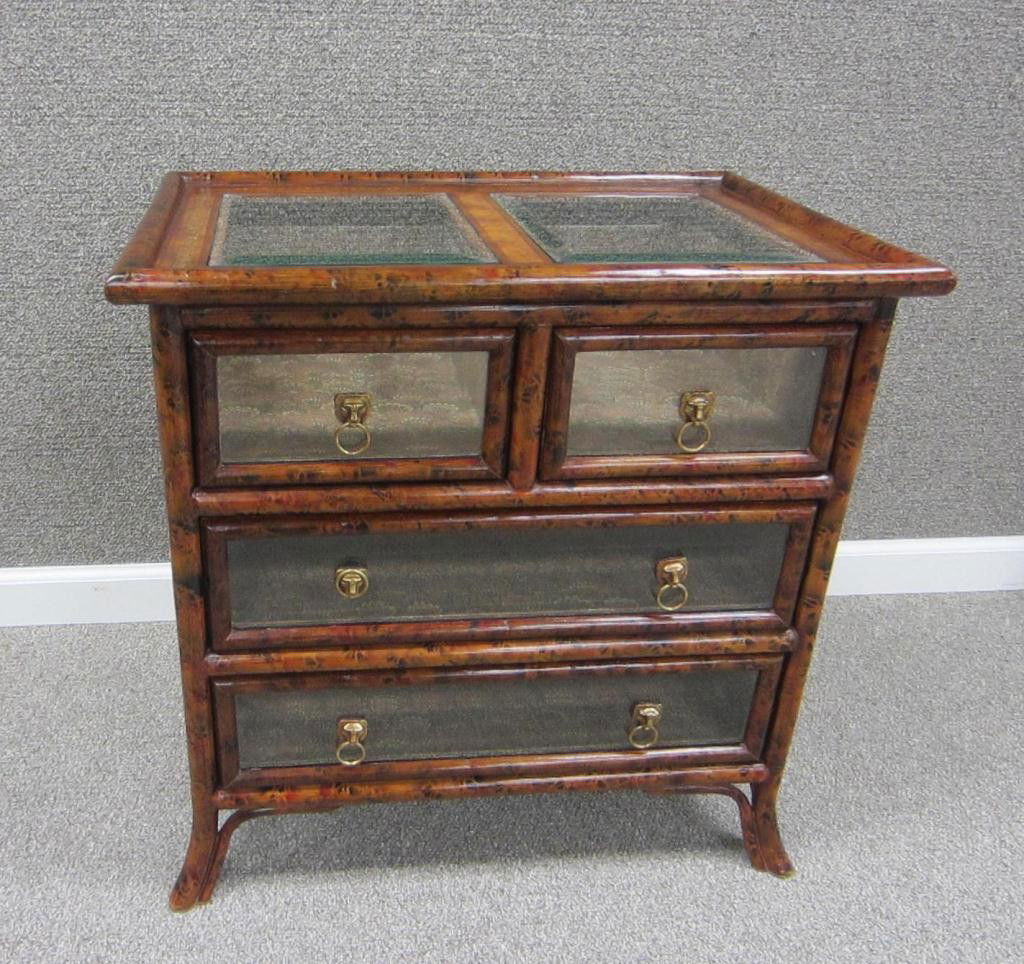 BAMBOO AND LEATHER DISPLAY CHEST BY MAITLAND SMITH: four-drawer with glass top and drawer fronts, tooled leather sides, brass lion ring handles, on splayed feet, metal tag of Maitland Smith, 24x24x16in.