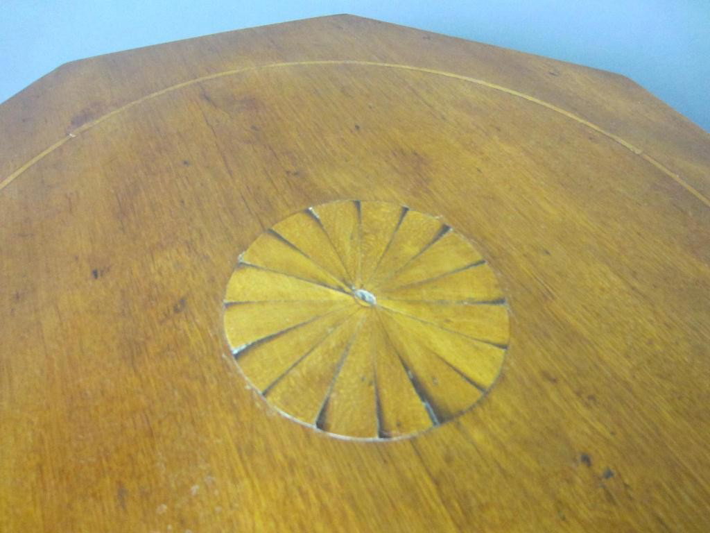 ANTIQUE MAPLE OCTAGONAL-TOP CANDLESTAND: single board top, central fan inlay and circular stringing, urn turned standard, dovetailed tripod base on slipper feet, 29x17in.