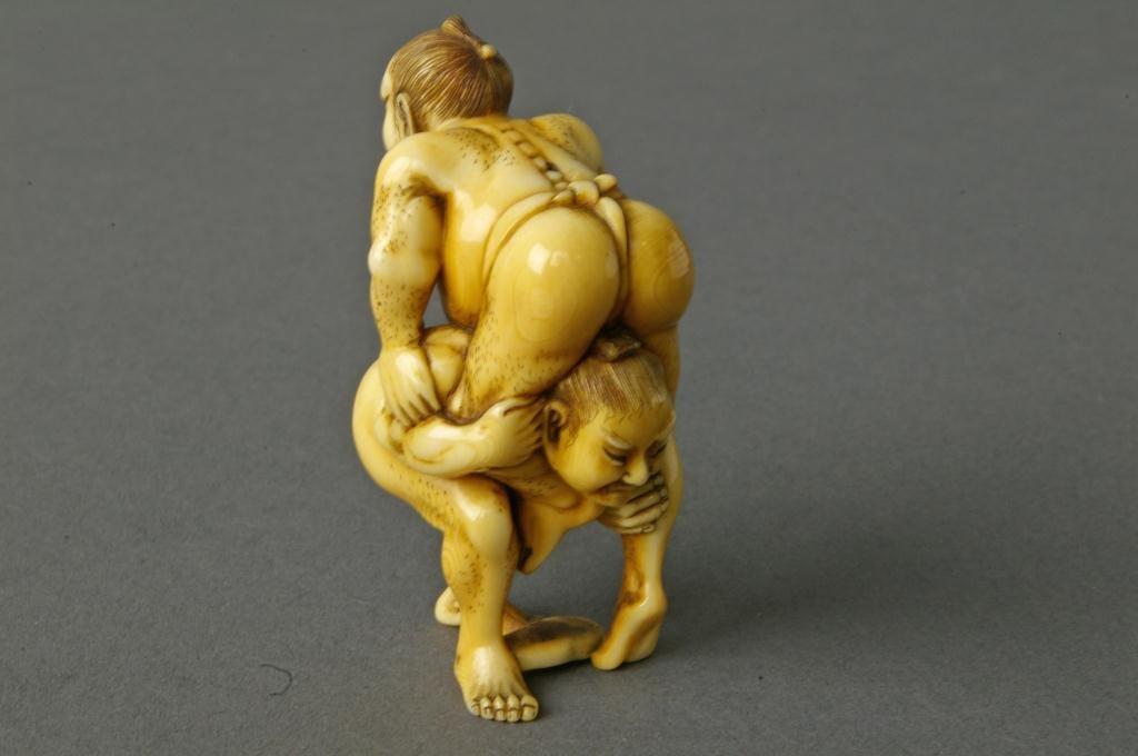 JAPANESE CARVED IVORY NETSUKE - WRESTLERS: finely carved as two Sumo wrestlers, signed, 2in. NO INTERNATIONAL SHIPPING.