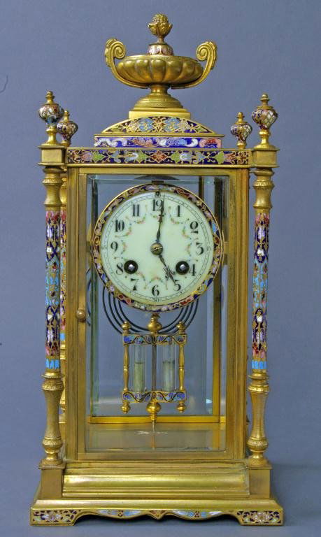 FRENCH BRONZE & CHAMPLEVE CRYSTAL REGULATOR CLOCK: with champleve decorated urn finial, columns and dial surround, enameled Arabic dial with floral swags, double mercury pendulum, works signed G. Magnin, running but not guaranteed, 15in.