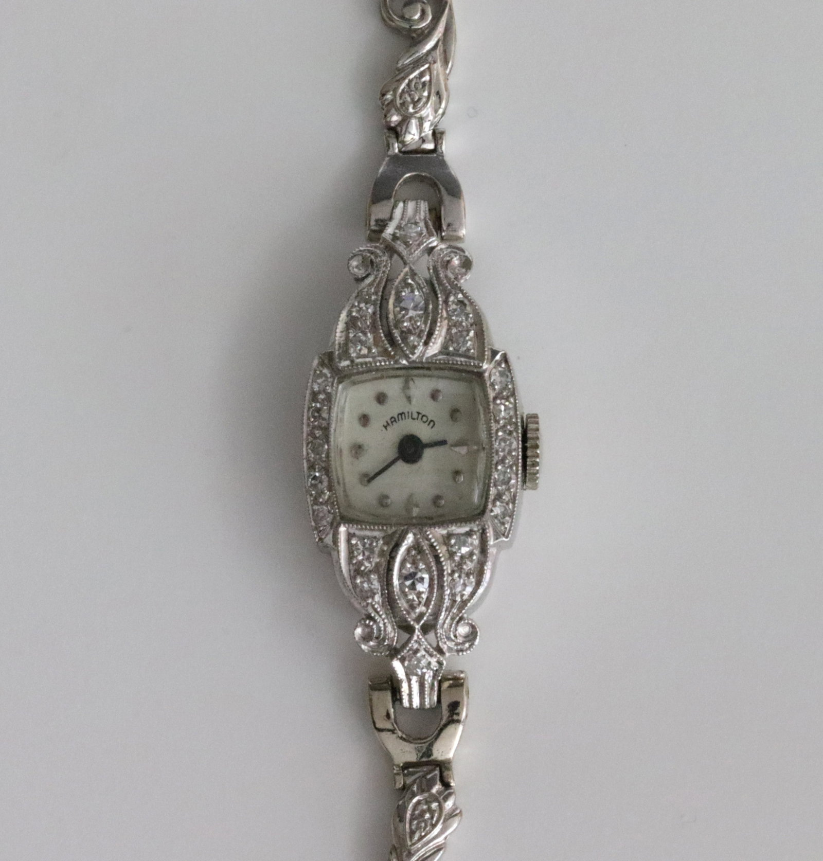 HAMILTON PLATINUM,14K & DIAMOND BRACELET WATCH: 23x13mm case set with 22 round diamonds approx. 0.35 carats, case back stamped '10% Irid. Plat', interior #001240, manual movement stamped '17 Jewels Hamilton USA N319623', replaced leaf link bracelet