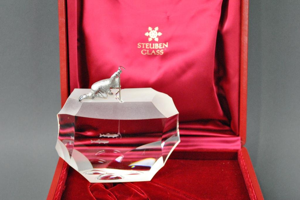 STEUBEN SCULPTURE - ARCTIC FISHERMAN: designed by James Houston, having an etched glass ice cap above a colorless glass body of water, a silvered metal Eskimo with his trident in hand peering through an ice crack waiting to spear his catc
