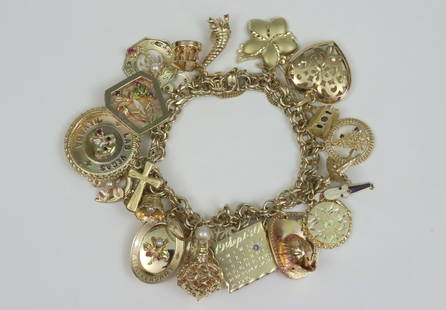 14K CHARM BRACELET WITH (25) 14K CHARMS: including a tricolor butterfly, a flower, a pierced puffy heart, a Christmas tree plaque, a church, a ballerina, a floral locket, a rose gold fireman's helmet, a painter's palette, a snowflake, a 1930