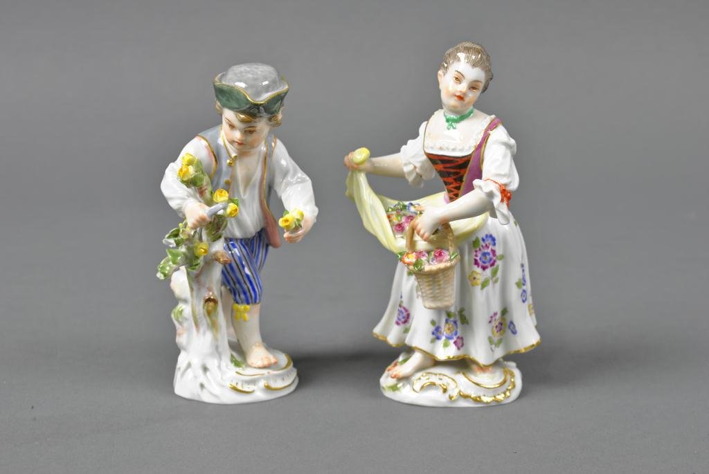 PAIR OF MEISSEN PORCELAIN FIGURINES: depicted with florals, boy with chips to two branch tips, blue crossed swords mark, tallest 5in.