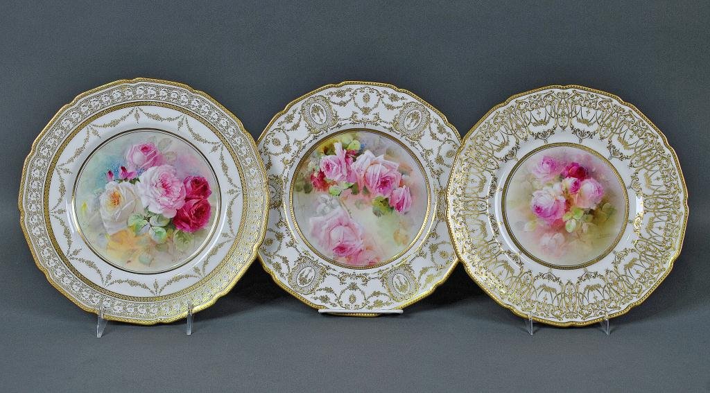 THREE ROYAL DOULTON ROSES CABINET PLATES: one by P. Curnock, one by C. Hart, and one signed illegibly, all with gilded embellishment, c.1910-1920, mainly 10.5in.