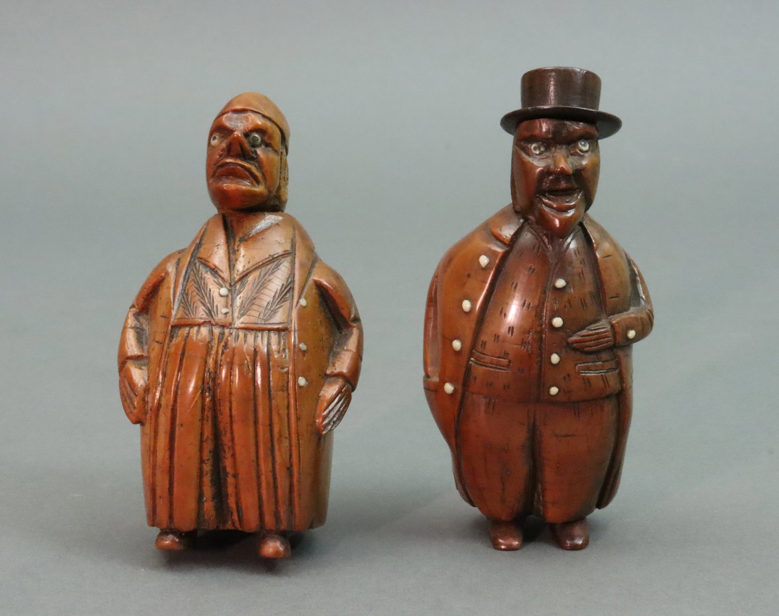 (2) CARVED COQUILLA NUT CHARACTERS: each depicting rotund gents with top coats and hats, with bone eyes and buttons, both with hinged snuff compartments, purchased Rogers de Rin, London, 1990's, tallest 4in.