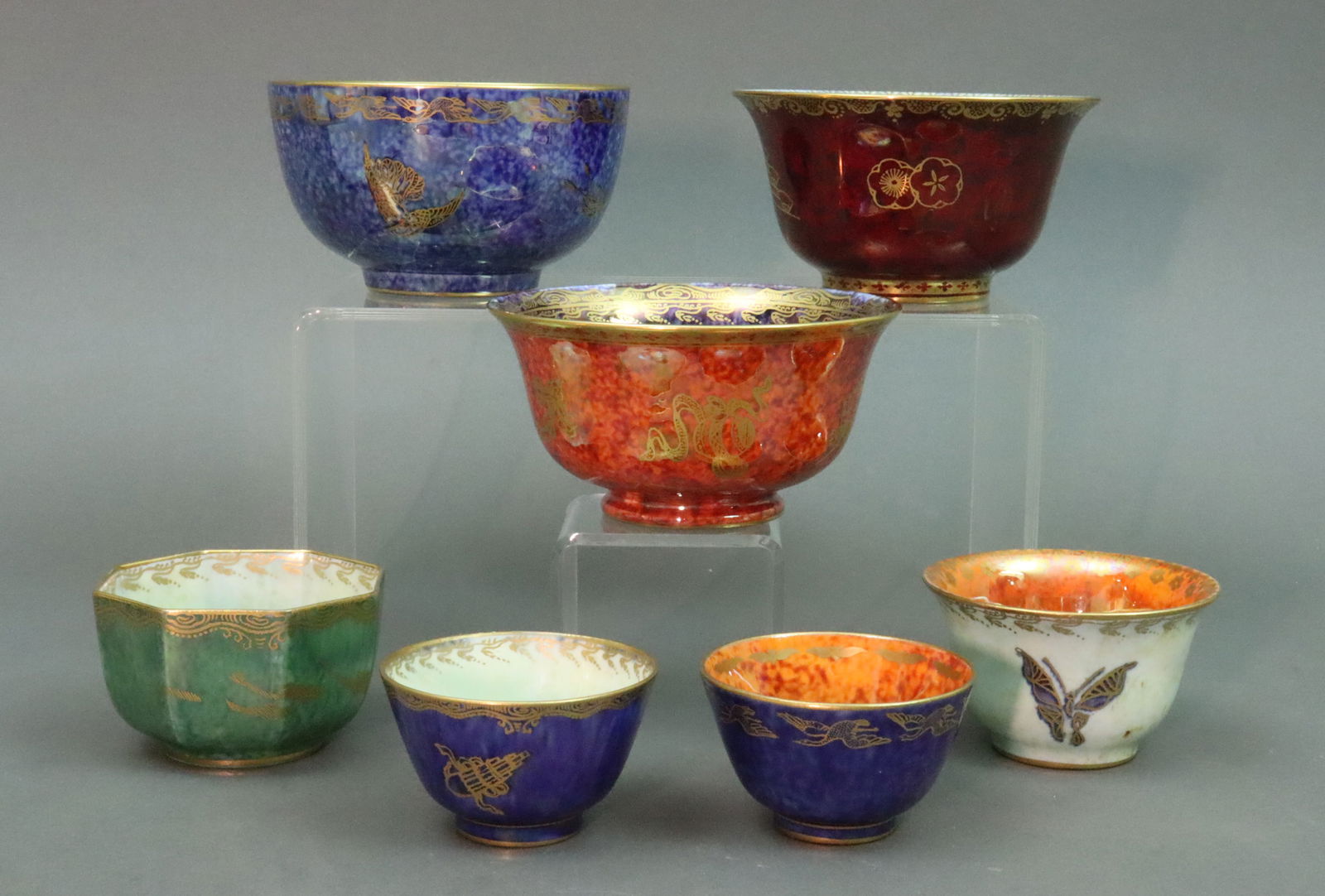 (7) WEDGWOOD FAIRYLAND LUSTER CUPS & BOWLS: lusterware porcelains designed by Daisy Makeig-Jones for Wedgwood, various patterns and gilt motifs including butterfly's, birds, fish, florals, etc., all with Z pattern numbers, UV clean with no evid