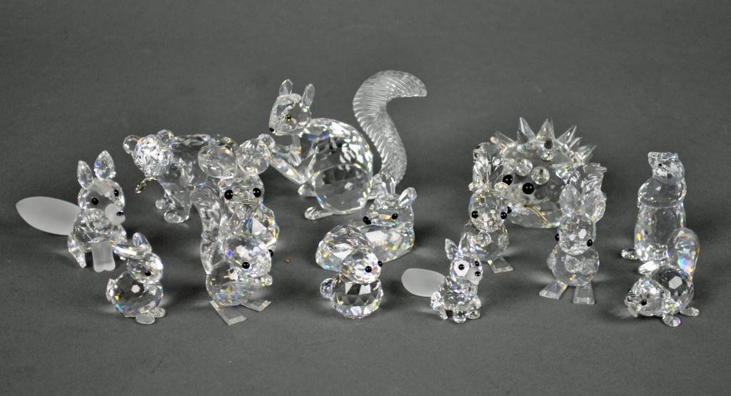 14-PIECE SWAROVSKI ANIMAL GROUP: including a hedgehog, a large squirrel, three small squirrels (one with box), a seated deer, two foxes (larger with box), a large bunny, two small bunnies, a bear with fish in mouth, a baby beaver, an