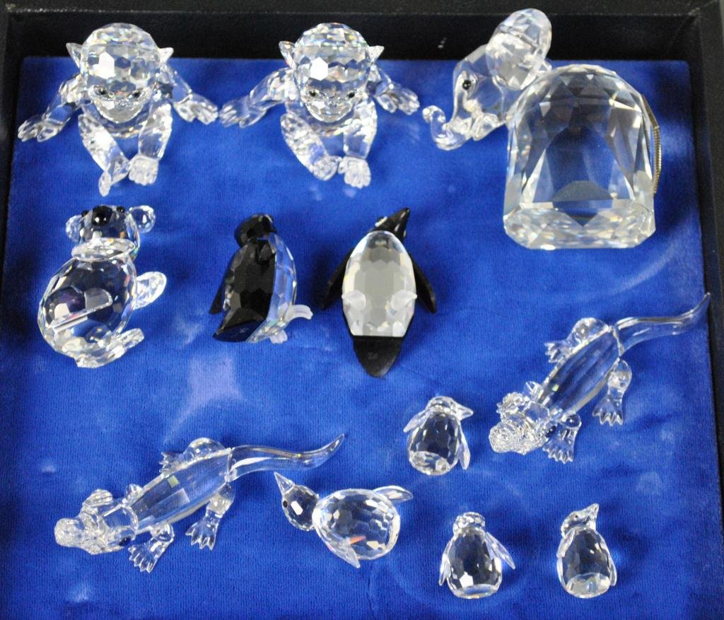 12-PIECE SWAROVSKI ZOO ANIMAL GROUP: including two seated monkeys, two alligators, a koala bear, an elephant, four penguins, and two black accented penguins (one with box)