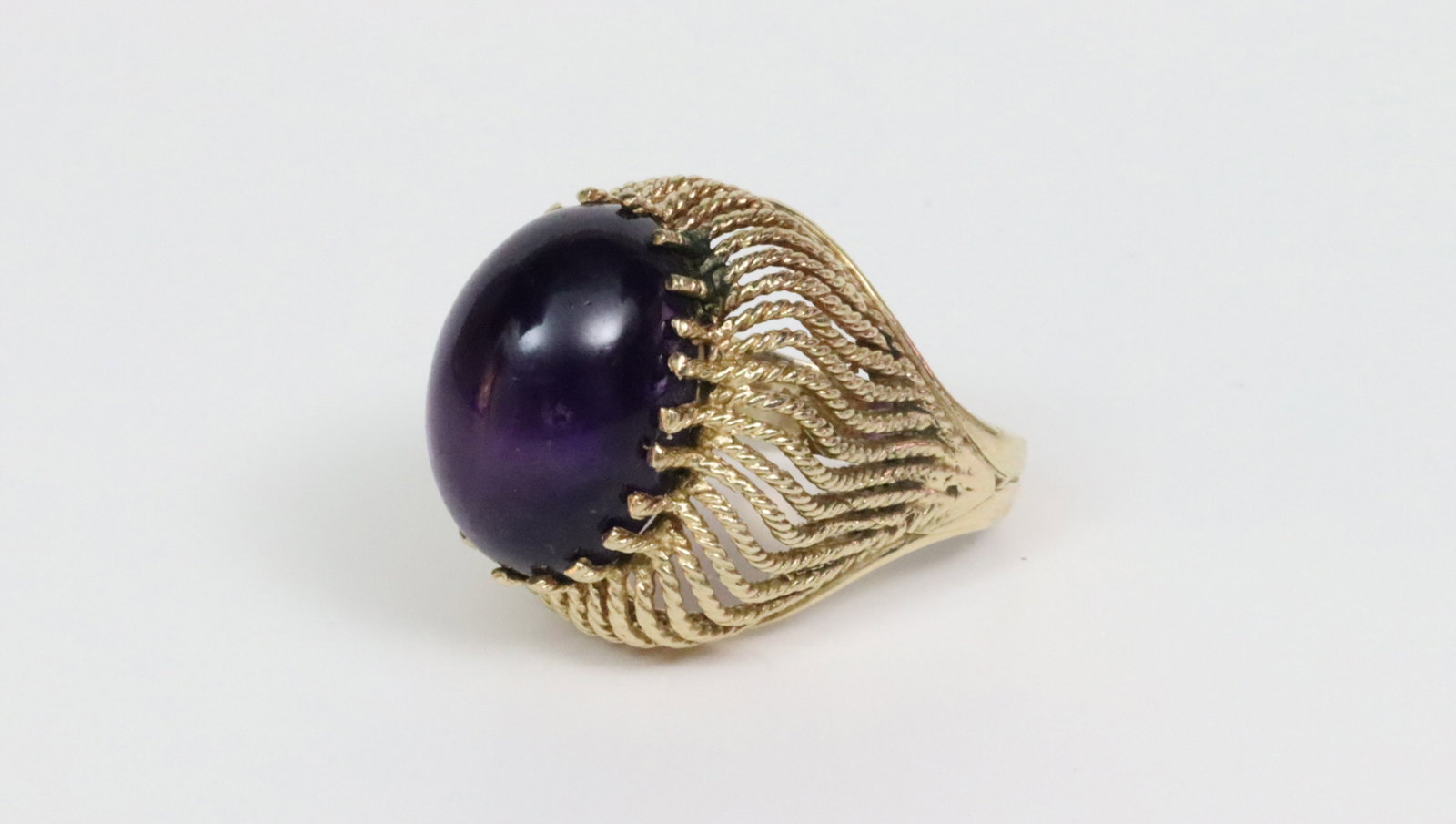 14K AMETHYST CABOCHON DOMED RING: set with an oval 19x14mm amethyst cabochon stone, in yellow gold rope trimmed reticulated setting (minor traces of solder dabs between 3 reticulations seen mainly under magnification), stamped 14K, si