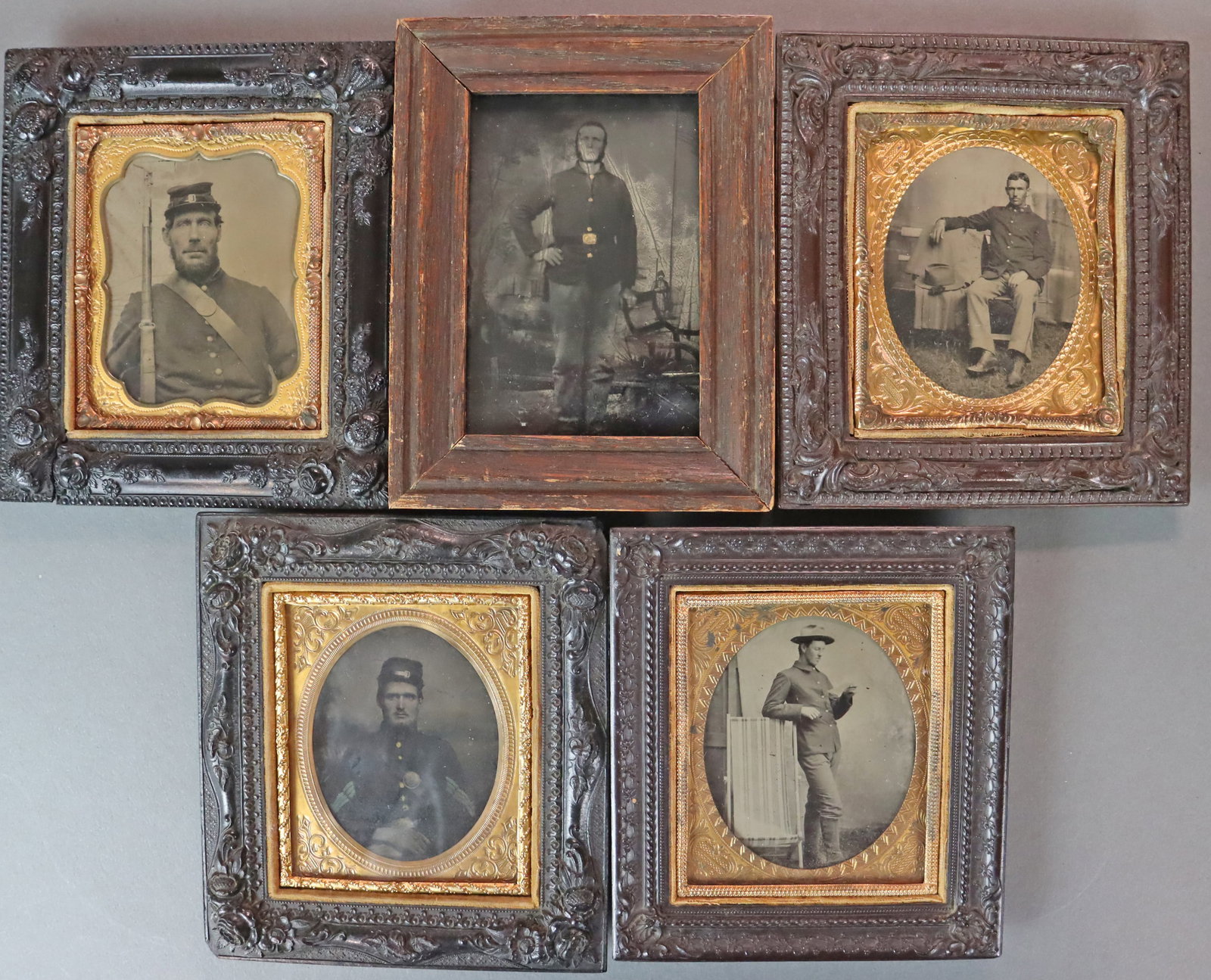 (5) FRAMED 1/6 PLATE TINTYPES - CIVIL WAR SOLDIERS: 4 set in period thermoplastic frames and one in wood, each depicting partial or fully uniformed soldiers, one armed with a rifle, 4 with scenic backdrops (one patriotic), 2 with button and/or buckle g