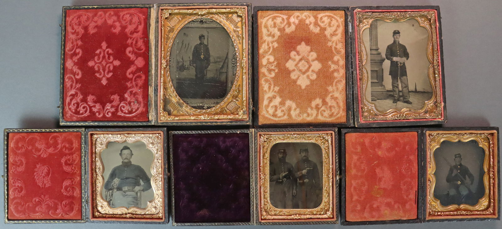 (5) TINTYPES OF ARMED CIVIL WAR SOLDIERS: Including 2 quarter plates and 3 sixth plates, all in full pressed paper cases depicting partial or fully uniformed soldiers, 2 with swords, 3 with rifles, and a duo (possibly brothers) each holding a